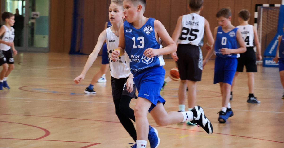 Zbliżenie na dwóch młodych zawodników, biegnących obok siebie na boisku.