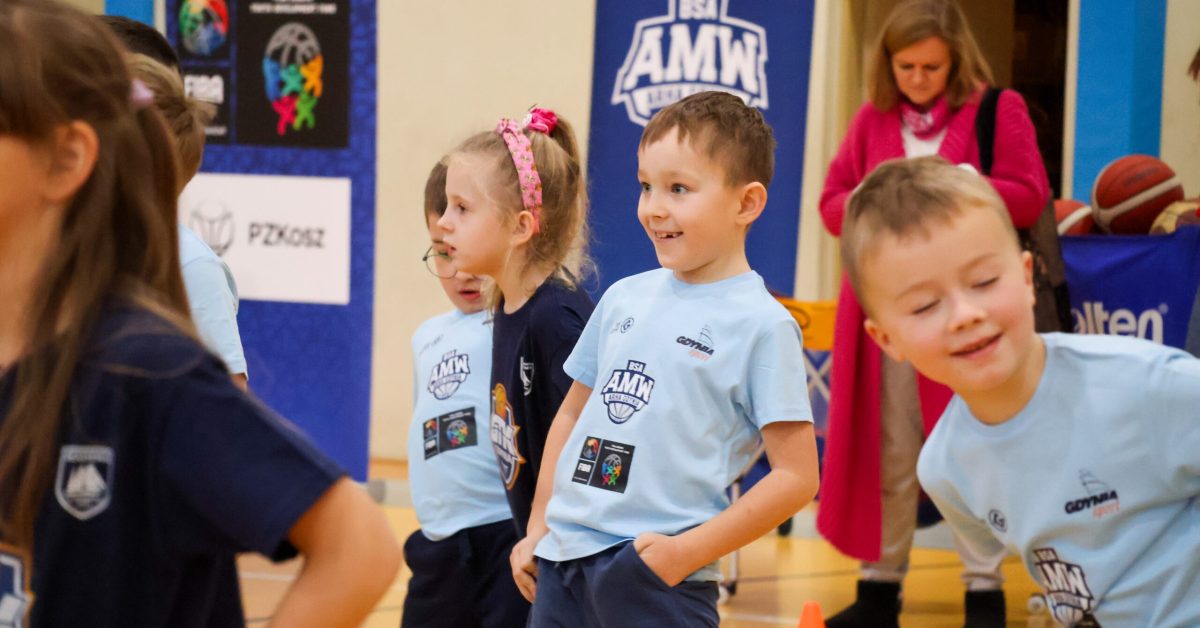 Dzieci w koszulkach sportowych biorą udział w ćwiczeniach.